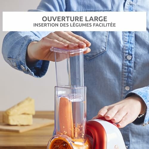 Personne utilisant un trancheur de légumes avec une grande ouverture.